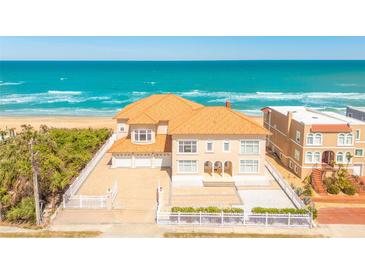 Stunning oceanfront home with a private sandy beach, garage, and white picket fence at 33 Ocean Shore Blvd, Ormond Beach, FL 32176