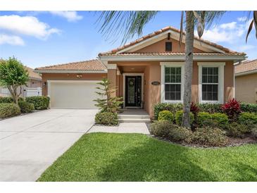 Charming single-story home showcasing lush landscaping, a tiled roof and attached two-car garage at 3451 Luna Bella Ln, New Smyrna Beach, FL 32168