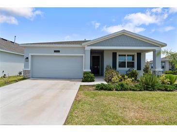 Charming single-story home featuring a well-manicured lawn, attached garage, and welcoming front porch at 34568 Shellback St, Leesburg, FL 34788