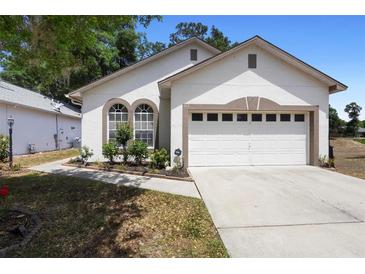 Charming single-Gathering home featuring arched windows, a two-car garage and well-maintained landscaping at 357 Heritage Estates Ln, Deland, FL 32720