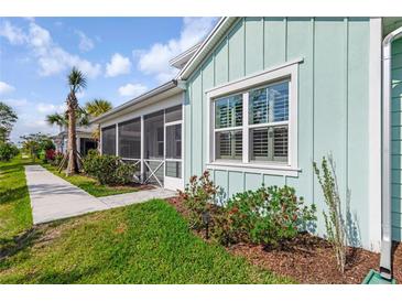 Charming coastal home with light blue siding, manicured lawn, and screened porch at 484 Landshark Blvd, Daytona Beach, FL 32124