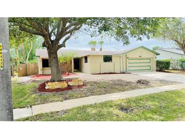 Charming single-story home featuring a light yellow exterior, well-manicured lawn, and an attached two-car garage at 552 Tiberon Cove Rd, Longwood, FL 32750