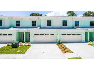 Bright and modern townhomes featuring individual driveways and attached garages at 561 Coronado Cove Road, New Smyrna Beach, FL 32168