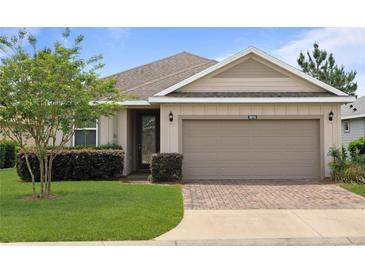 Charming single-story home with a well-manicured lawn and a brick driveway at 5610 Nw 37Th Lane Rd, Ocala, FL 34482