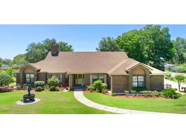 Charming brick home featuring a well-manicured front lawn and classic architectural details at 585 Summerhaven Dr, Debary, FL 32713
