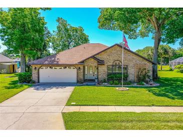 Charming brick home features a well-manicured lawn and an attached two-car garage at 61 Bryan Cave Rd, South Daytona, FL 32119