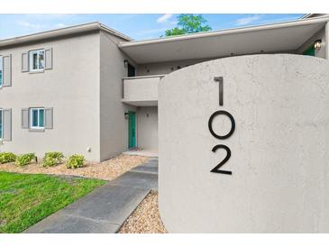 Inviting condo exterior featuring a well-maintained facade, lush landscaping, and clearly visible unit number 102 at 102 Bob White Ct # 102C, Daytona Beach, FL 32119