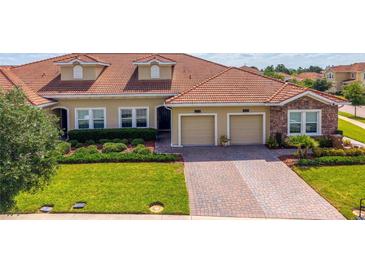 Beautiful single Gathering home featuring a red tile roof, manicured lawn, and a two-car garage at 1079 Quaker Ridge Ln, Davenport, FL 33896