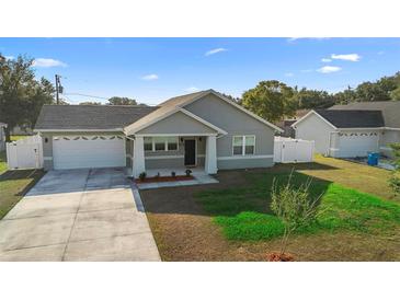 Charming single-story home with a well-manicured lawn and a spacious two-car garage at 1626 Lansfield Ave, Deltona, FL 32738