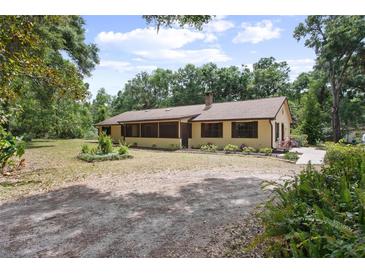 Charming single-story home with lush landscaping and a long driveway at 1690 S Adelle Ave, Deland, FL 32720