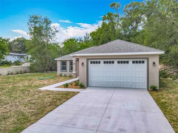 Charming single-story home featuring a gray roof, a two-car garage, and a well-manicured front lawn at 200 S Montgomery Ave, Deland, FL 32720