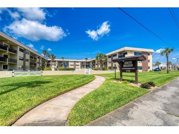 Beautiful view of the Ormond Breakers Condominium with manicured lawn and a clear blue sky at 2100 Ocean Shore Blvd # 1120, Ormond Beach, FL 32176