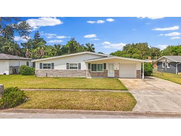 Charming single-story home featuring stone accents, attached garage, and well-maintained front yard at 2144 Brian Ave, South Daytona, FL 32119
