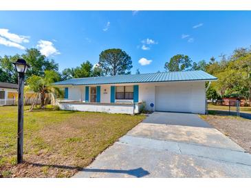Charming single-story home with a blue metal roof and well-maintained landscaping at 2214 Danforth Ave, Deltona, FL 32738