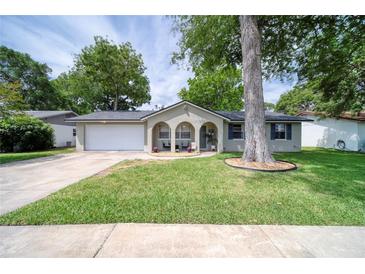 Charming one-story home featuring a well-manicured lawn, attached garage, and inviting front porch with arched entryways at 2254 Green St, South Daytona, FL 32119
