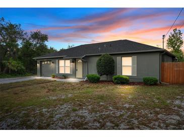 Charming single-story home with gray exterior, manicured shrubs, and a cozy two-car garage at 333 Redwood Ave, Orange City, FL 32763