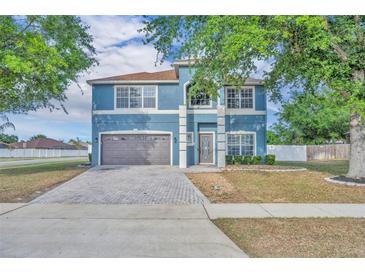 Charming two-story blue home with a well-manicured lawn and brick paved driveway at 486 Sycamore Springs St, Debary, FL 32713