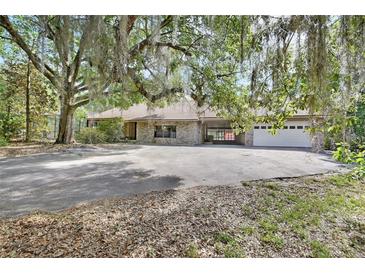Sprawling home with brick exterior, porte-cochere, large driveway, and two-car garage at 5265 Myakka Rd, De Leon Springs, FL 32130