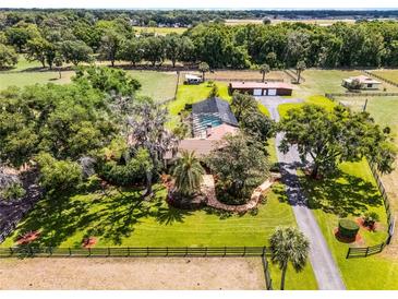 Expansive property showcasing lush landscaping, pool, outbuildings, and a gated entrance, offering a private retreat at 5549 Aragon Ave, De Leon Springs, FL 32130