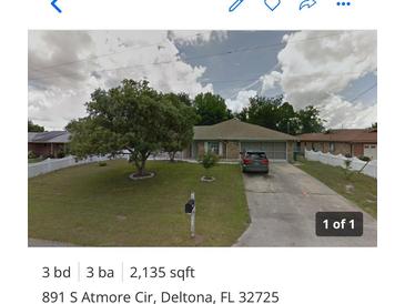 Charming home featuring a lush front yard, mature tree, and inviting curb appeal at 891 S Atmore Cir, Deltona, FL 32725