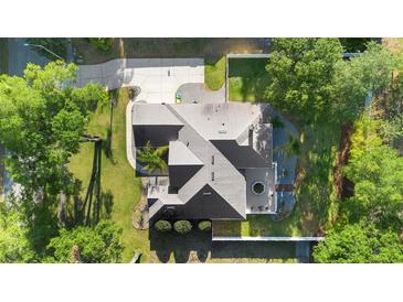 Aerial view of a well-maintained home featuring a long driveway and manicured lawn at 1523 Red Plum Holw, Deland, FL 32720
