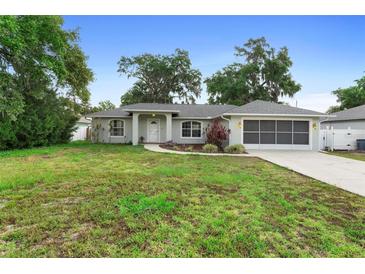 Charming single-story home features a well-maintained lawn and a screened garage at 1715 Queen Palm Dr, Edgewater, FL 32132