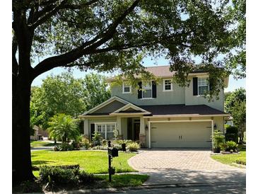 Charming two-story home with a brick driveway, lush landscaping, and a cozy, inviting curb appeal at 201 Asterbrooke Dr, Deland, FL 32724