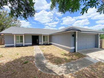 Charming single-story home with a gray exterior, walkway, and well-maintained landscaping at 206 Westmoor Bnd, Orlando, FL 32835