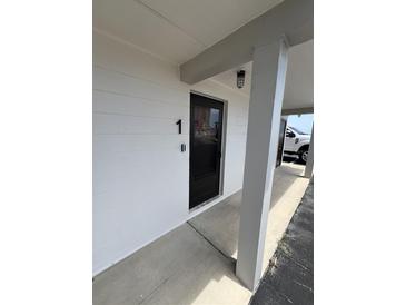 View of the condo's front door numbered '1' and its exterior features at 2101 N Atlantic Ave # 10, Daytona Beach, FL 32118