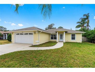 Charming single-story home featuring a well-manicured lawn and a two-car garage and bright exterior color at 2526 Chester Ave, New Smyrna Beach, FL 32168