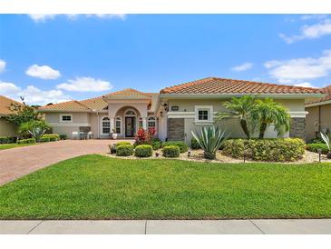 Inviting home featuring a tile roof, manicured lawn, and lush landscaping at 2814 S Asciano Ct, New Smyrna Beach, FL 32168