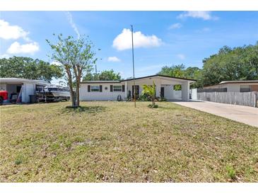 Charming single-story home with a carport, white exterior and well-manicured lawn at 2824 Oak Lea Dr, South Daytona, FL 32119