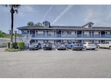Exterior shot of a multi-Gathering building, featuring parking spaces and a palm tree on a sunny day at 313 Dirksen Dr # B15, Debary, FL 32713
