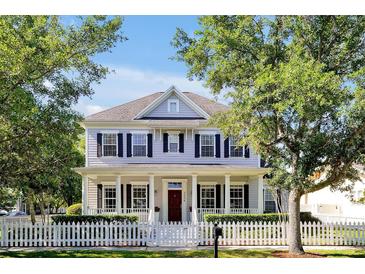 Charming two-story home featuring a welcoming front porch, white picket fence, and well-manicured landscaping at 3698 Lower Park Rd, Orlando, FL 32814