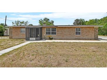 Charming brick home featuring a screened front porch and well-maintained landscaping at 636 W Mathis St, Deland, FL 32720