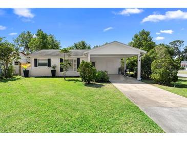 Charming single-story home with a well-maintained lawn and a covered carport at 708 Wayne Ave, New Smyrna Beach, FL 32168