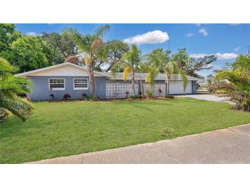 Charming single-story home featuring a well-maintained lawn, palm trees, and a classic concrete block privacy screen at 88 Valencia Dr, Ormond Beach, FL 32176