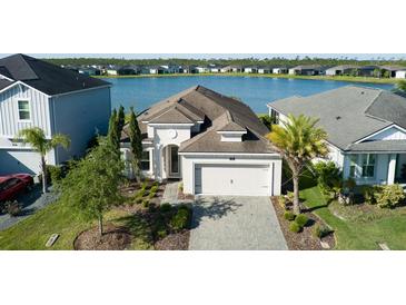 Stunning single Gathering home with lake view, manicured lawn, and paver driveway at 133 Azure Mist Way, Daytona Beach, FL 32124