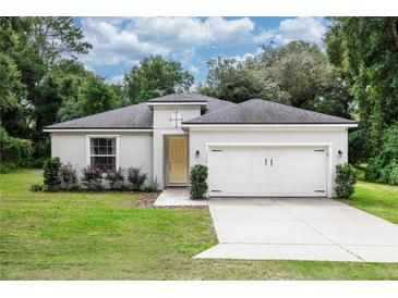 Charming single-story home featuring a gray exterior, complemented by a two car garage and well-manicured landscaping at 1388 15Th St, Orange City, FL 32763