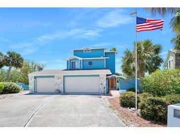 Charming blue home with a three-car garage and an American flag waving proudly at 14 Marsh Ct, Ponce Inlet, FL 32127