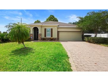 Charming home featuring a brick driveway, two car garage, a well-manicured lawn and shuttered windows at 1480 Leitrim Loop, Apopka, FL 32703