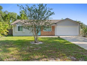 Charming single Gathering home featuring a brick facade, neutral colors, and a well maintained front yard at 2416 Candlewick St, Deltona, FL 32738