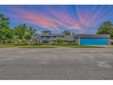 Charming multi-story home featuring a large garage, manicured lawn, and picturesque landscaping at 2551 Cross Country Dr, Port Orange, FL 32128