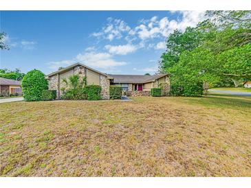 Charming single-story home featuring stone accents, mature landscaping, and a well-maintained yard at 2704 Burgoyne Pl, Deland, FL 32720
