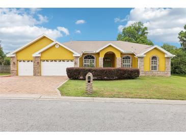 Charming single-story home with a two-car garage, brick accents and manicured front lawn at 2940 Se 23Rd Ave, Ocala, FL 34471