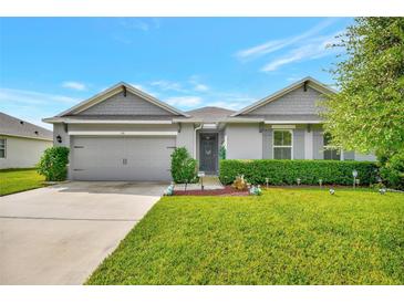 Charming single-story home featuring a well-manicured lawn and a two-car garage at 316 Nowell Loop, Deland, FL 32724
