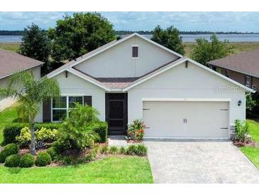 Charming single-Gathering home featuring a two-car garage, well-maintained landscaping, and a cozy front entrance at 343 Lazio Cir, Debary, FL 32713