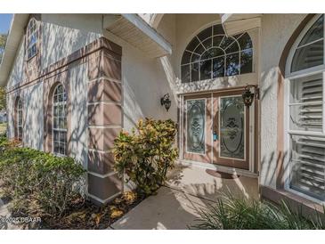 Welcoming front entrance features decorative glass doors and a large arched window for lots of natural light at 3601 Galway Ln, Ormond Beach, FL 32174