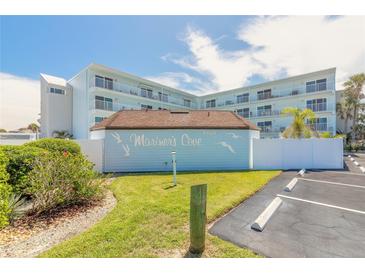 Beautiful exterior view of Mariner's Cove building with manicured lawn and parking at 3700 S Atlantic Ave # 413, New Smyrna Beach, FL 32169