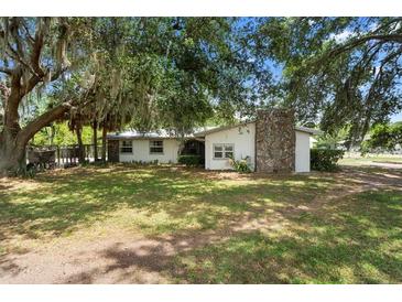 Charming single-story home with a stone chimney and beautiful mature trees in the front yard at 4145 Rambler Ave, St Cloud, FL 34772